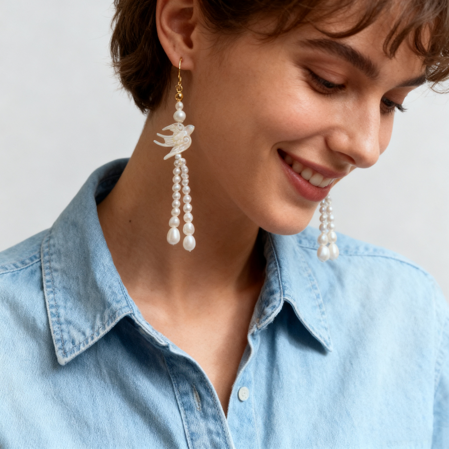 Long pearl drop earrings with shell carved swallow detail