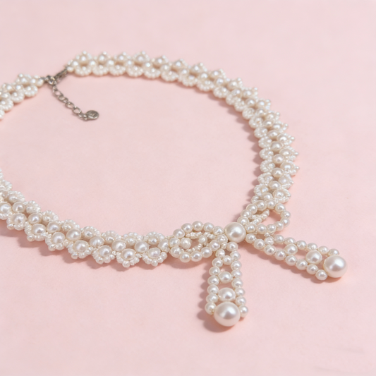 Hand beaded pearl bow statement necklace worn on model