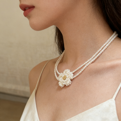 Hand beaded floral necklace made with pearl style beads, featuring a delicate flower centerpiece and double strand design