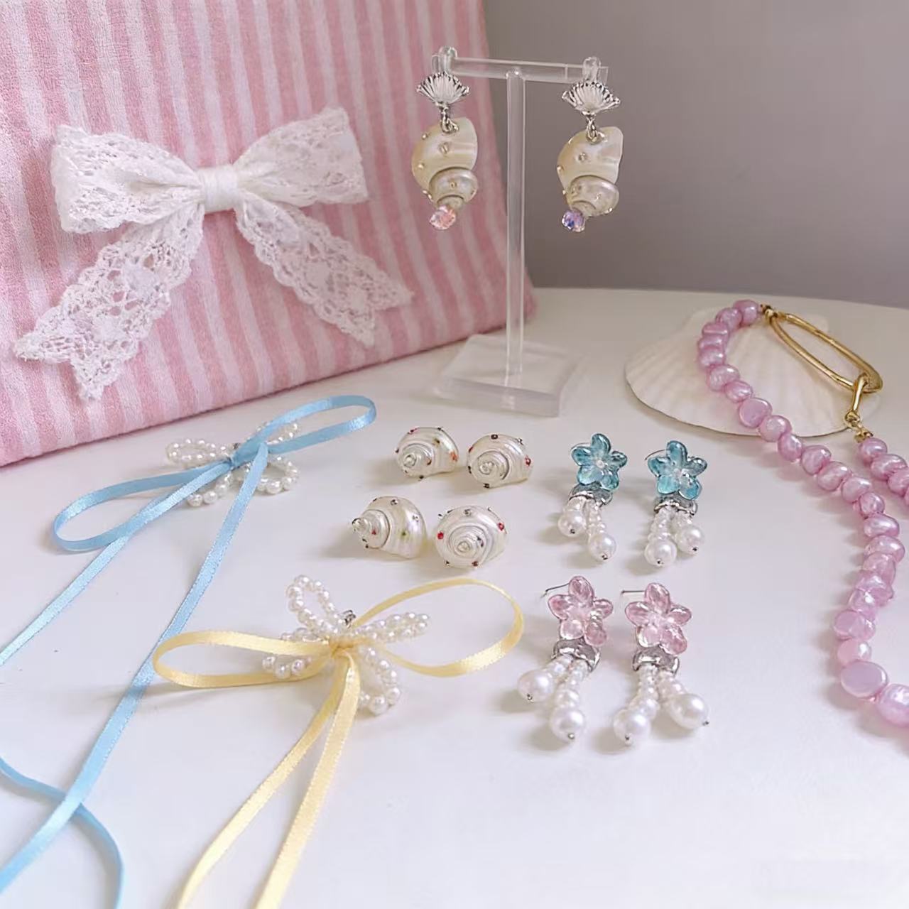 Imitation pearl bow earrings with flowing ribbon detail