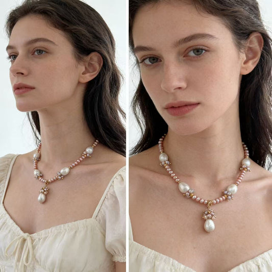 Pink pearl drop charm necklace worn at collarbone
