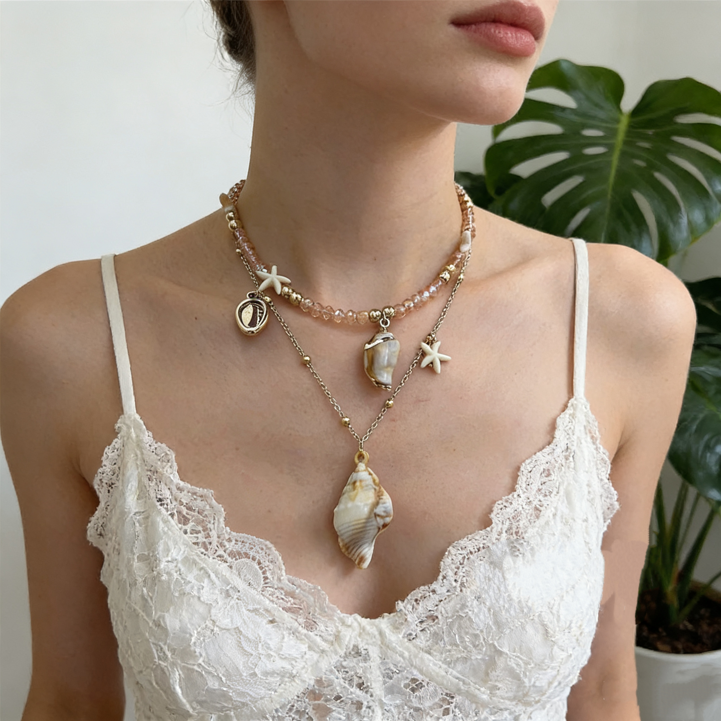 Layered necklace with shell pendants and pearl charms