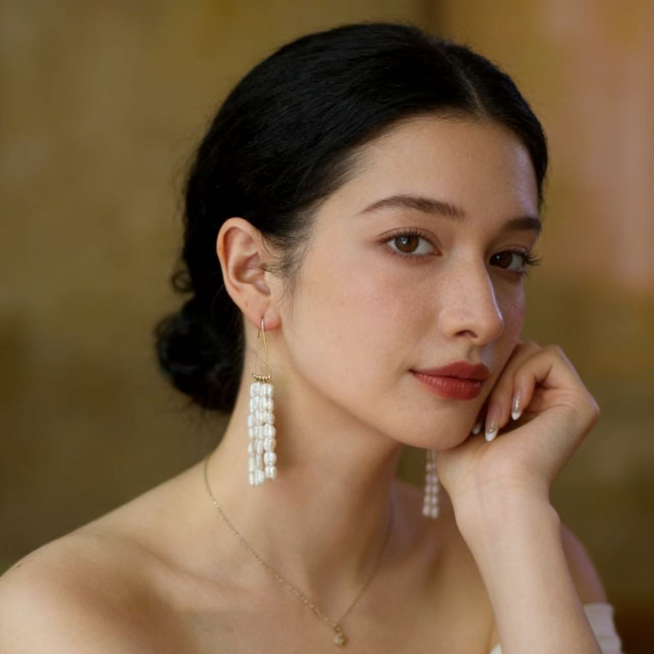 Multi strand pearl fringe drop earrings on pink background