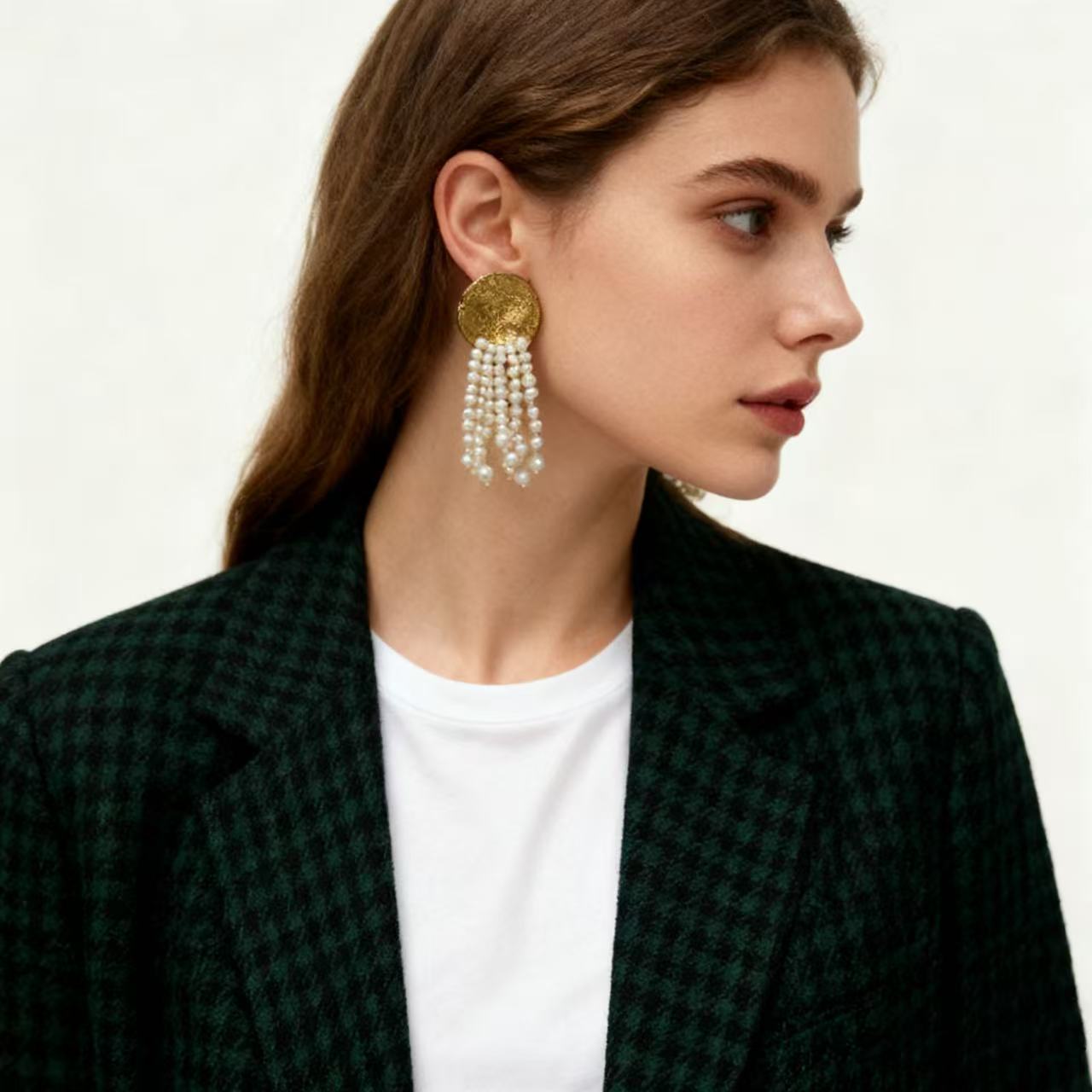 Textured brass pearl drop earrings worn on ear