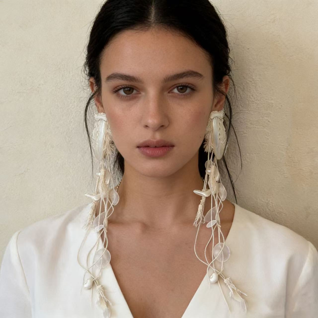 Natural shell statement earring worn with black off shoulder top