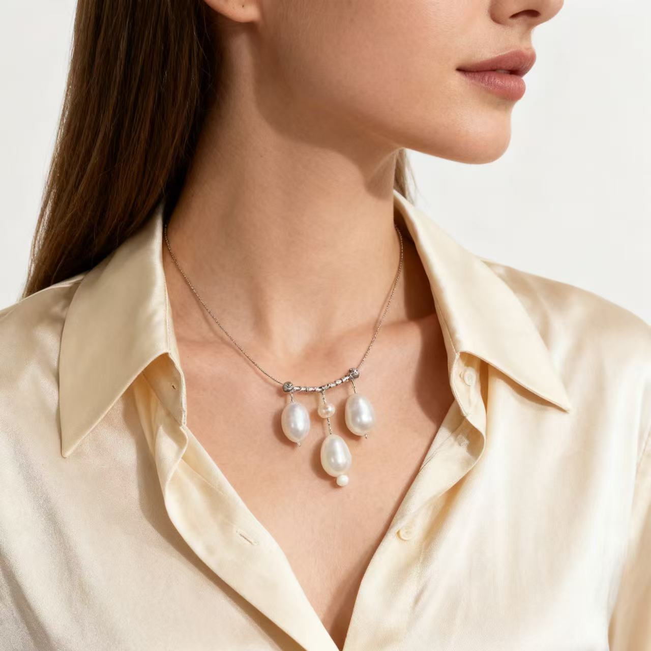 Pearl drop necklace worn with a cream knit top