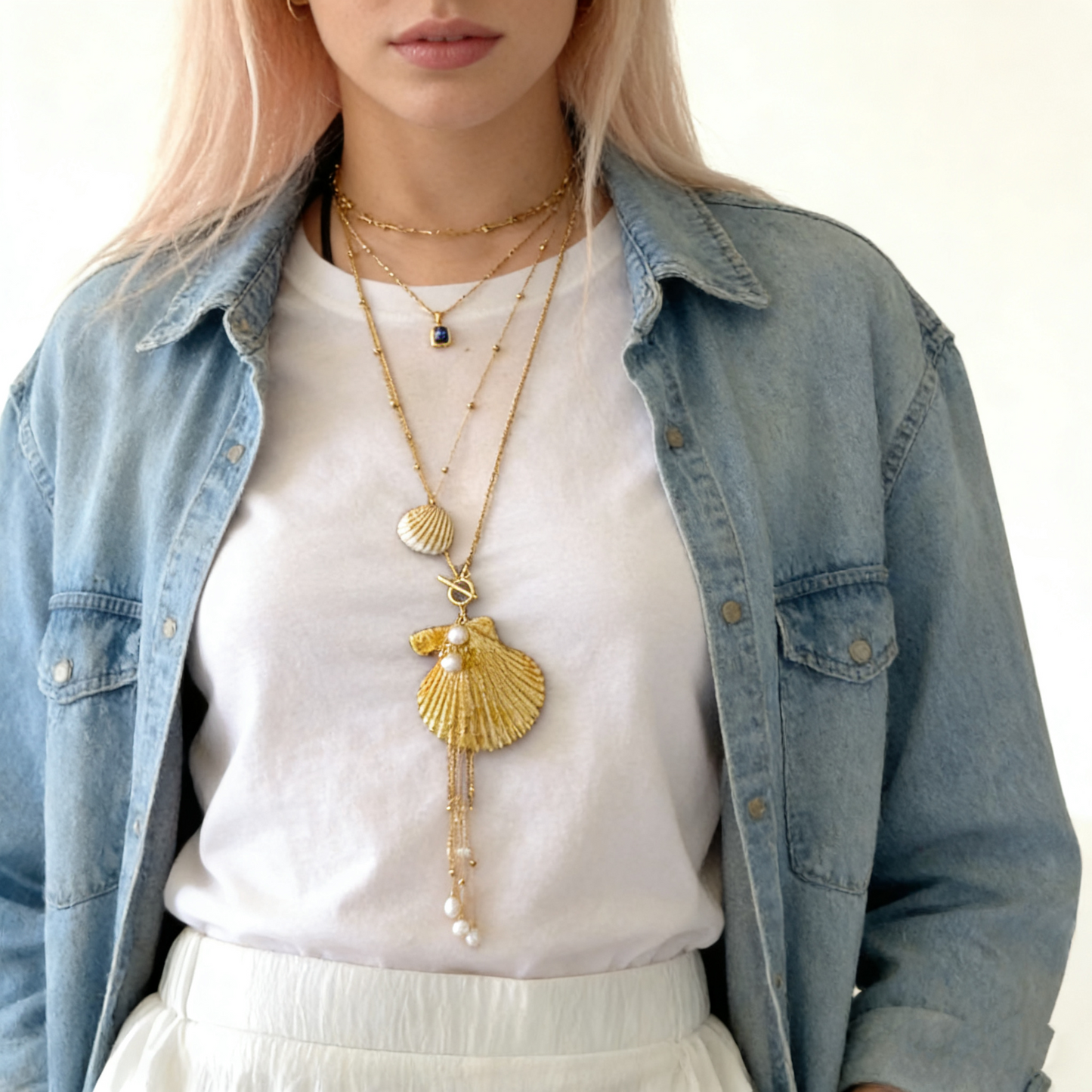 Detail view of natural shell pendant decorated with gold foil and pearl accents