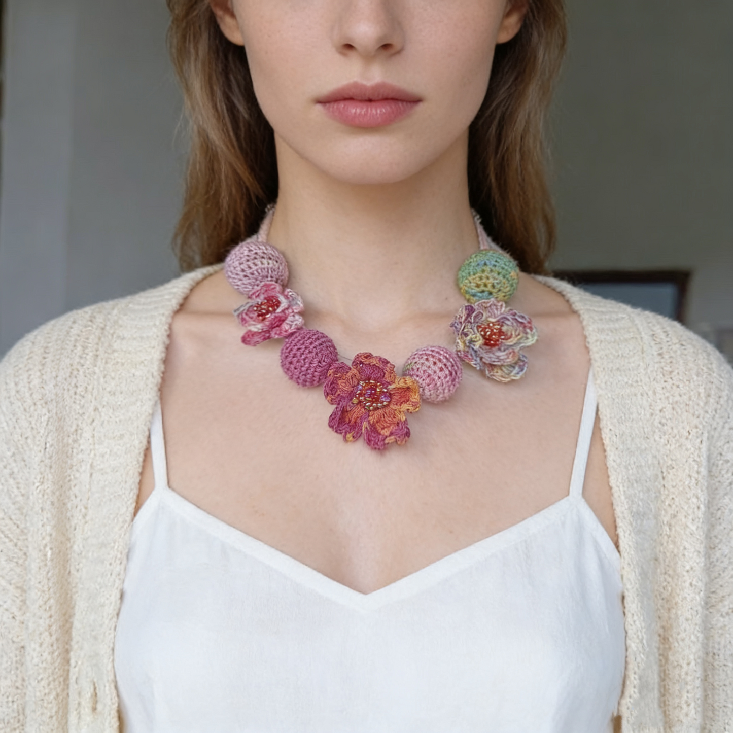 Flat lay of handmade crochet floral necklace on light fabric background