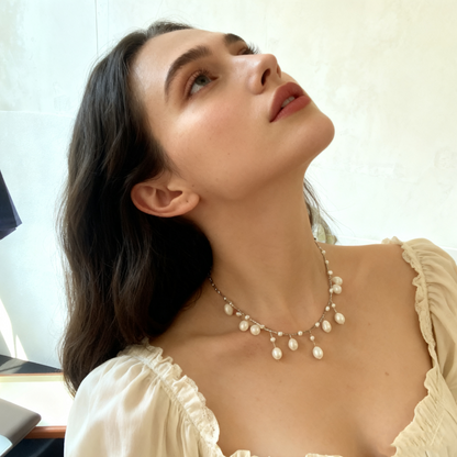 Delicate pearl drop necklace worn on model