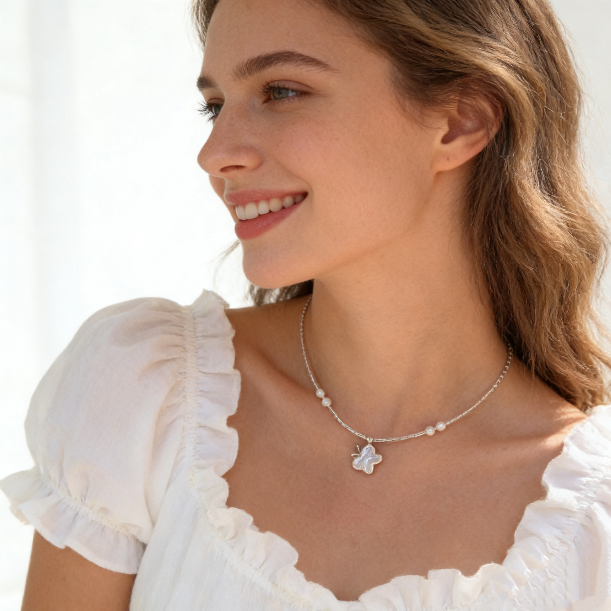 Minimal baroque pearl butterfly pendant necklace flat lay