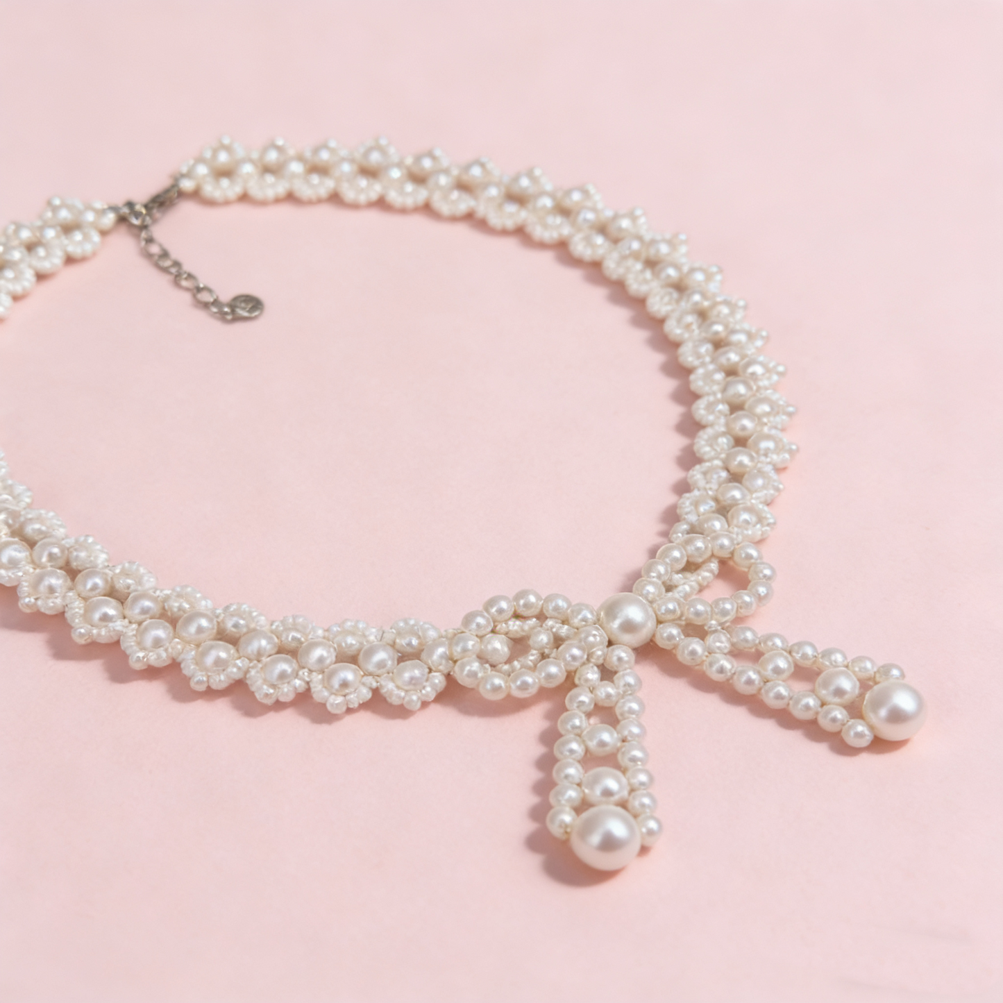 Hand beaded pearl bow statement necklace worn on model