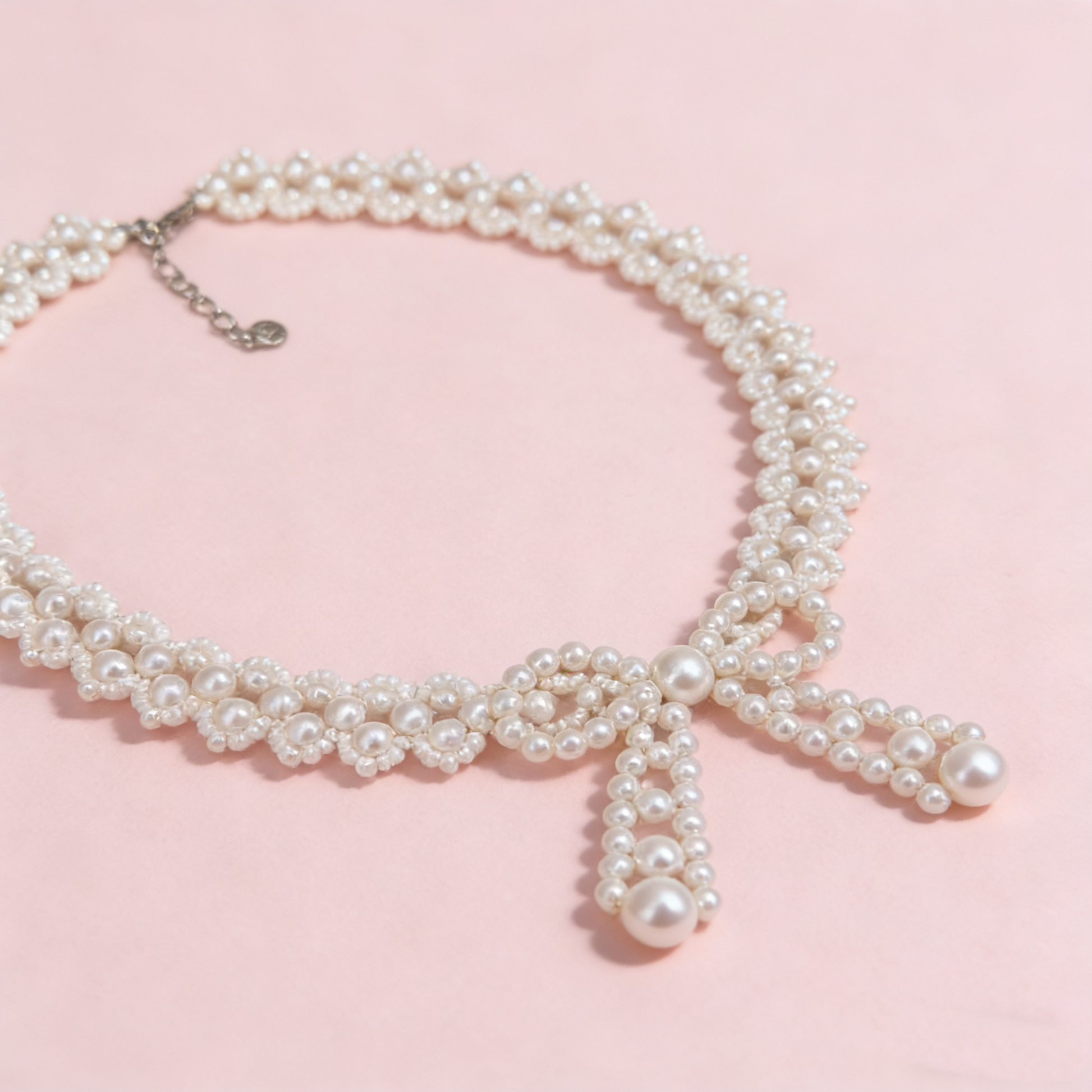 Hand beaded pearl bow statement necklace worn on model