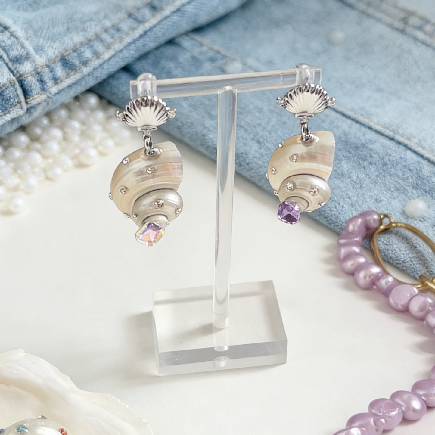 Handmade shell earrings with pearl and crystal accents on display stand