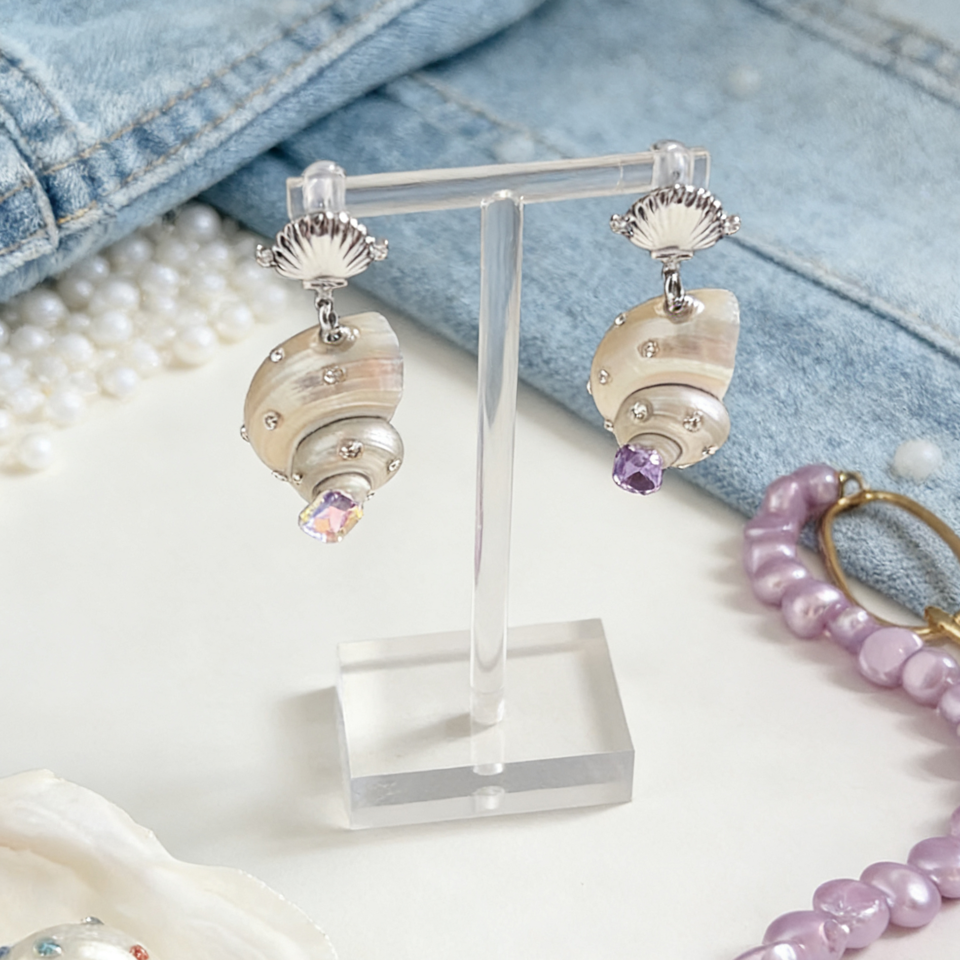 Handmade shell earrings with pearl and crystal accents on display stand